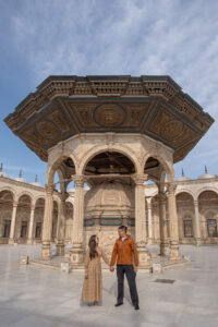 Kamy and Eric holding hands and looking at each other in a mosque.